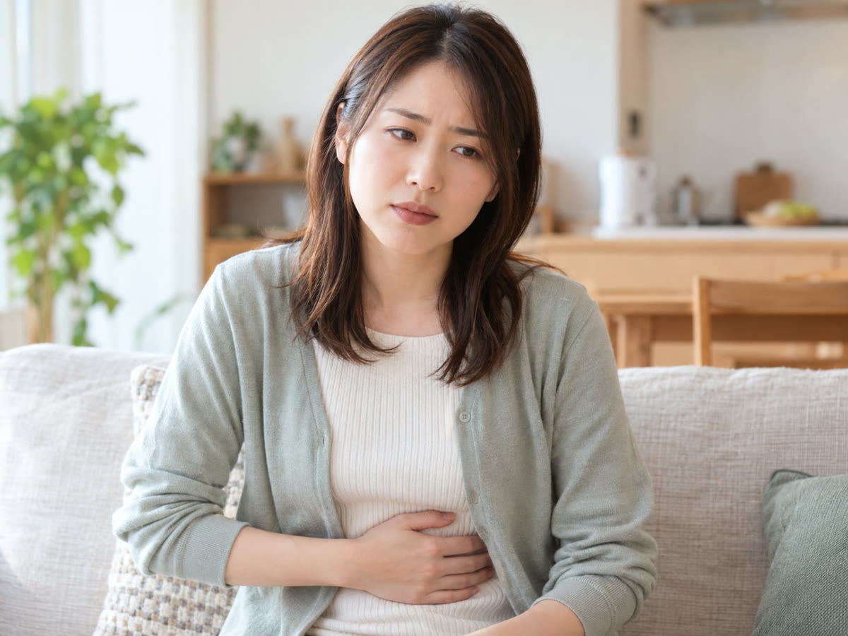 お腹に手を当てる女性